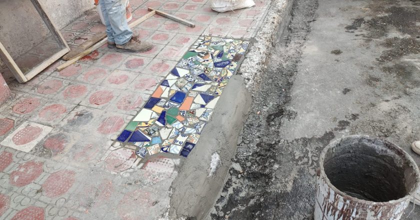 Reparan banquetas con pedacería de mosaico